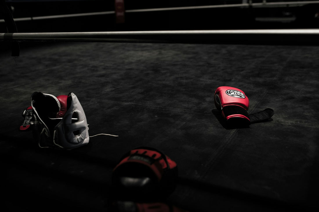 A pair of red boxing gloves hanging in a gym