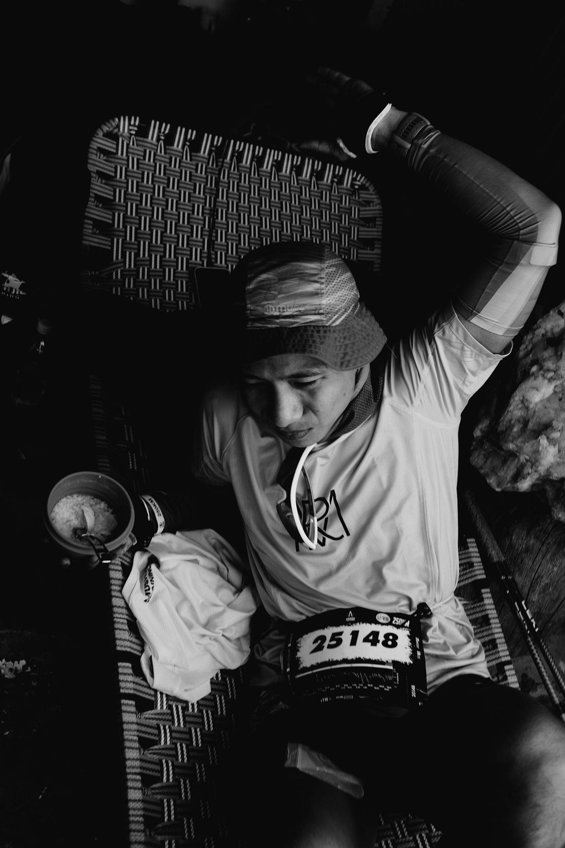 Runner wearing a race bib resting after finishing a race