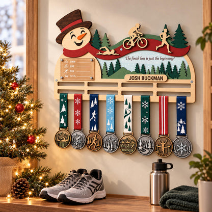Christmas triathlon medal hanger – snowman design beside a Christmas tree